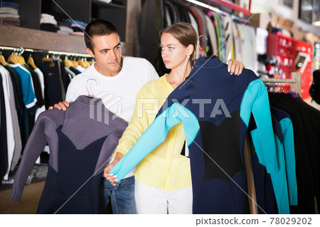 Couple searching wetsuits for surf Couple searching wetsuits for surf 78029202