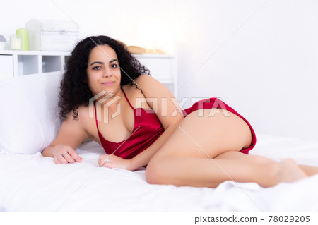 Woman in lingerie enjoying lying on bed Woman in lingerie enjoying lying on bed 78029205