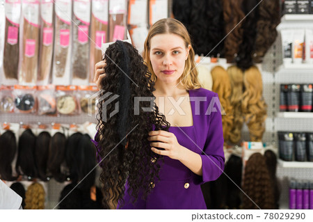 Girl choosing wigs from natural hair Girl choosing wigs from natural hair 78029290