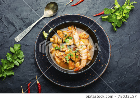 Tom yum soup with seafood and coconut milk,top view 78032157