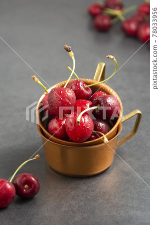 Fresh summer fruits, cherries in metal cups, gray background. Fresh summer fruits, cherries in metal cups, gray background. 78033956