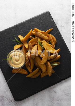 Top view of fried potatos with herbs and sauce. Golden roasted potatoes, fast homemade food. Top view of fried potatos with herbs and sauce. Golden roasted potatoes, fast homemade food. 78034089