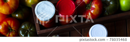 Homemade adjika in jars and Tomatoes on wooden table. Flat lay Homemade adjika in jars and Tomatoes on wooden table. Flat lay 78035468