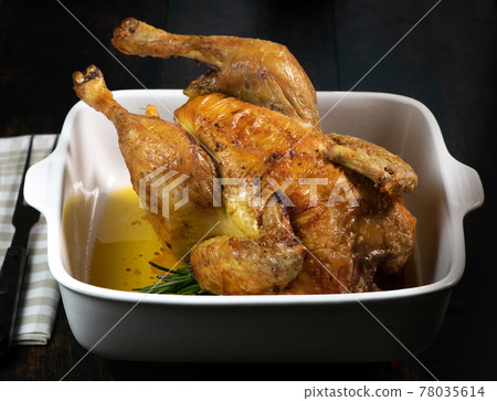 Roast chicken on a white plate, on a black wooden background 78035614