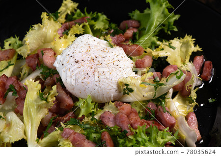 Recipe for poached egg cut with a knife, bacon and salad  78035624