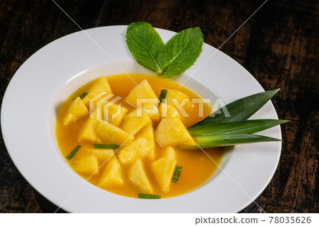 Fresh pineapple dessert recipe with mint orange coulis 78035626
