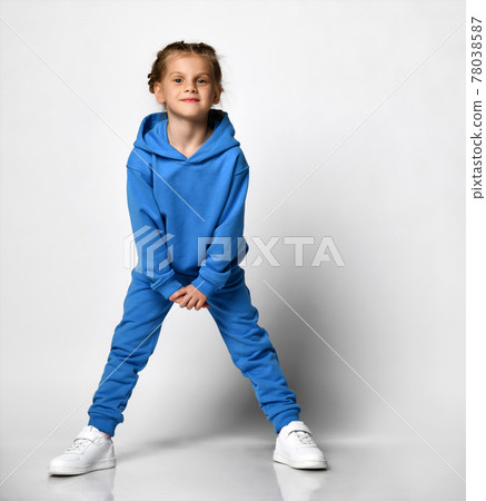 Smiling cute little girl in a blue tracksuit with Smiling cute little girl in a blue tracksuit with 78038587