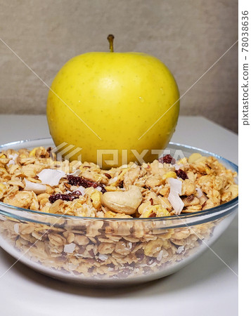 Green apple and breakfast cereal and muesli in a bowl on a white background. close-up 78038636
