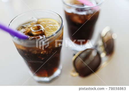 Two glasses with cola ice and lemon are on table 78038863