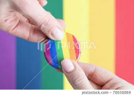 Two people hold lgbt sign against background of flag of sexual minorities 78038869