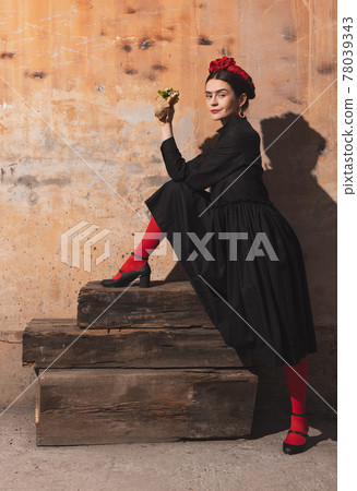 Portrait of young woman in image of famous artist, personality on vintage background. Retro style, comparison of eras concept. Portrait of young woman in image of famous artist, personality on vintage background. Retro style, comparison of eras concept. 78039343