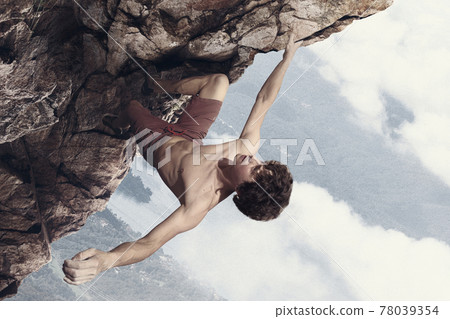 Young man professional rock climber practicing in mountains over cloudy sky background. Collage, artwork Young man professional rock climber practicing in mountains over cloudy sky background. Collage, artwork 78039354