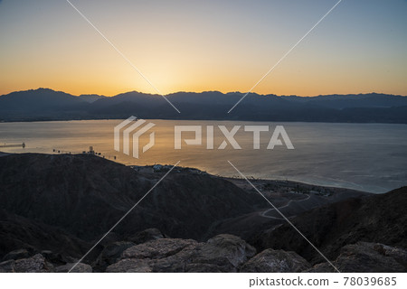 Dawn rises beyond the Aqaba mountains. Sunrise over the Red Sea. A look at Mount Shlomo, Eilat, Israel. 78039685