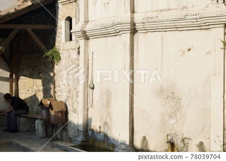 Old street fountain with a copper bowl Tas and carved flower on the wall in Safranbolu. UNESCO site. Turkey. 78039704