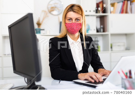 Woman in mask working at office Woman in mask working at office 78040160