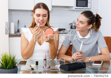 Friends talking and applying make up 78040258