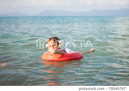 adorable toddler toddler swim in the sea in a special inflatable life ring. adorable toddler toddler swim in the sea in a special inflatable life ring. 78040767