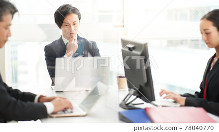 A businessman working towards a PC in the office A businessman working towards a PC in the office 78040770