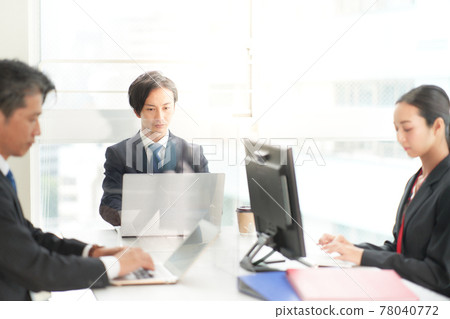 Business person working towards a PC in the office 78040772