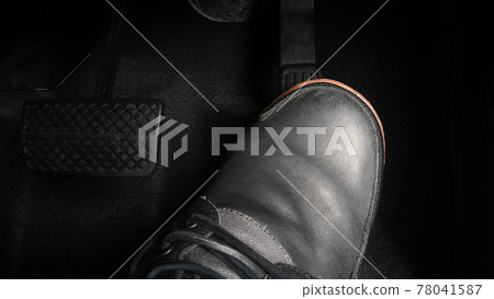 Foot pressing foot pedal of a car to drive. Accelerator and brake pedal in a car. Driver driving the car by pushing accelerator and break pedals of the car. inside vehicle. control pedal. Close up. 78041587