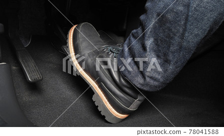 Foot pressing foot pedal of a car to drive. Accelerator and brake pedal in a car. Driver driving the car by pushing accelerator and break pedals of the car. inside vehicle. control pedal. Close up. 78041588