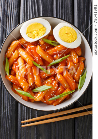 Korean tteokbokki spicy rice cake with eggs close-up in a bowl. Vertical top view 78041991