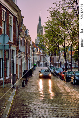 Delft cobblestone street with car in the rain 78042214