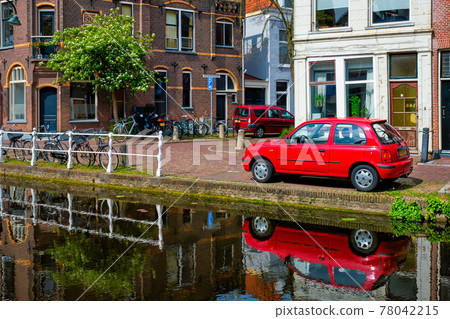 Cars on canal embankment in street of Delft. Delft, Netherlands 78042215