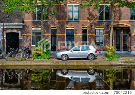 Cars on canal embankment in street of Delft. Delft, Netherlands 78042216