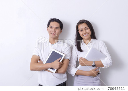 An Asian business woman standing in a modern collaborative office, smiling, looking at the screen of a tablet device, preparing a presentation about electronic devices. Cutting edge technology, 78042311