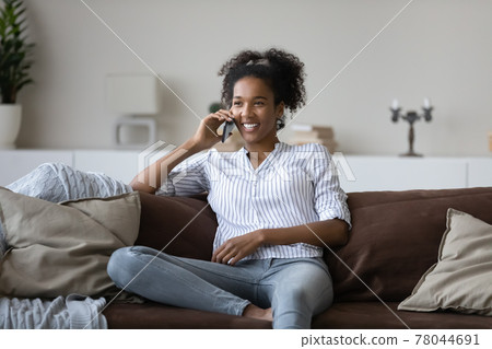 Happy african american woman holding cellphone conversation. 78044691
