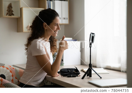 Smiling hispanic female blogger enjoying vlogging activity. 78044735