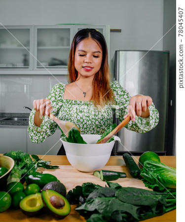 Asian girl cooking healthy vegetarian and vegan food, vegetables and fruits in the kitchen, healthy 78045407