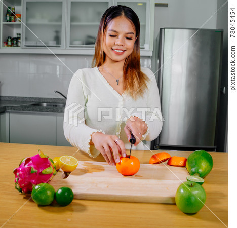 Asian girl cooking healthy vegetarian and vegan food, vegetables and fruits in the kitchen, healthy 78045454