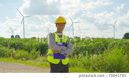 Portrait of Asian windmill engineer man, worker smiling, working on site at wind turbines field or farm, renewable clean energy source. Eco technology for electric power. industry environment. People 78045793