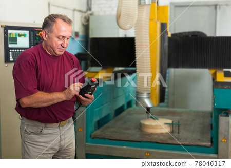 Confident worker drives 3d machine with remote control Confident worker drives 3d machine with remote control 78046317