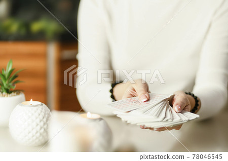 Selective Focus of two hands shuffling and adjusting tarot cards 78046545