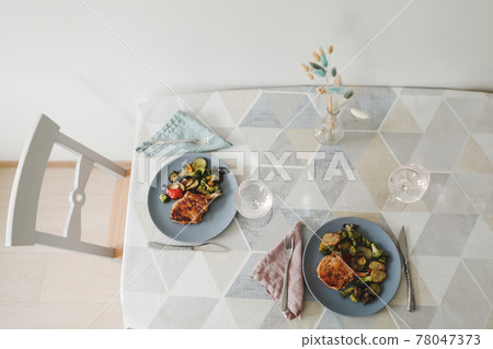 Table set on dinning table at home. Grilled steak and vegetables Table set on dinning table at home. Grilled steak and vegetables 78047373