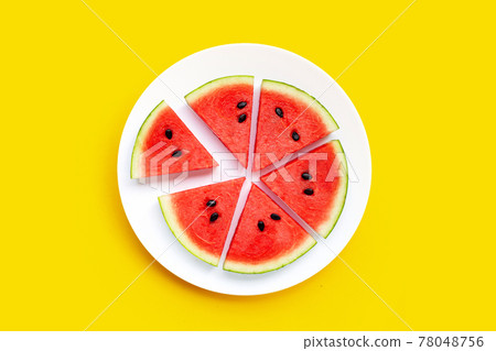 Watermelon slices in white plate on yellow background. 78048756