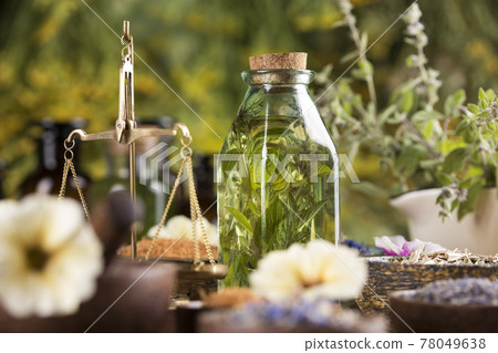 Fresh herbs and oil, wooden table background Fresh herbs and oil, wooden table background 78049638