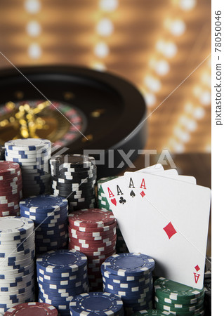 Poker Chips on gaming table, roulette wheel in motion, casino background 78050046