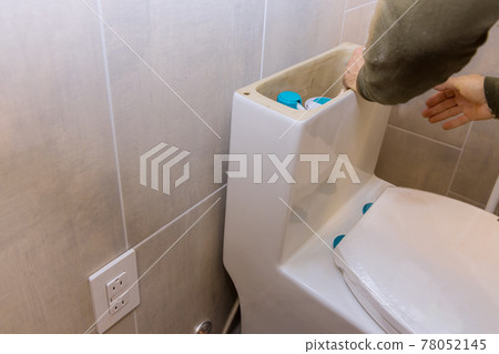 A bathroom remodeling project installation of a new white toilet bowl. unfinished interior of renovation bathroom A bathroom remodeling project installation of a new white toilet bowl. unfinished interior of renovation bathroom 78052145