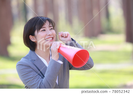 A woman holding a megaphone and cheering A woman holding a megaphone and cheering 78052342