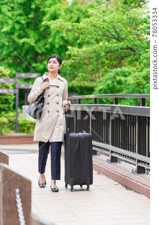 Business woman walking with a suitcase (carry back) 78053334