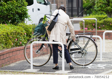 A business woman who locks a bicycle key at a bicycle parking lot 78054212