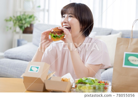 一位女士正在吃外賣訂購的食物 78055056