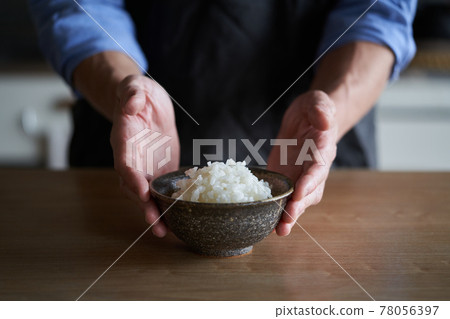 Men offering white rice 78056397