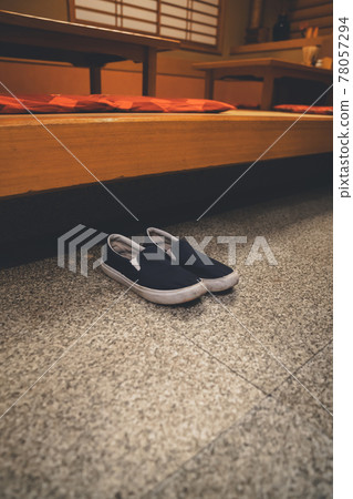 Customer's shoes placed in front of the restaurant's small rise Customer's shoes placed in front of the restaurant's small rise 78057294