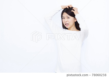 A woman in her thirties suffering from itchy scalp A woman in her thirties suffering from itchy scalp 78060238