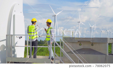 Teamwork of Asian windmill engineer group, worker working on site at wind turbines field or farm, renewable clean energy source. Eco technology for electric power. industry nature environment. People 78062075